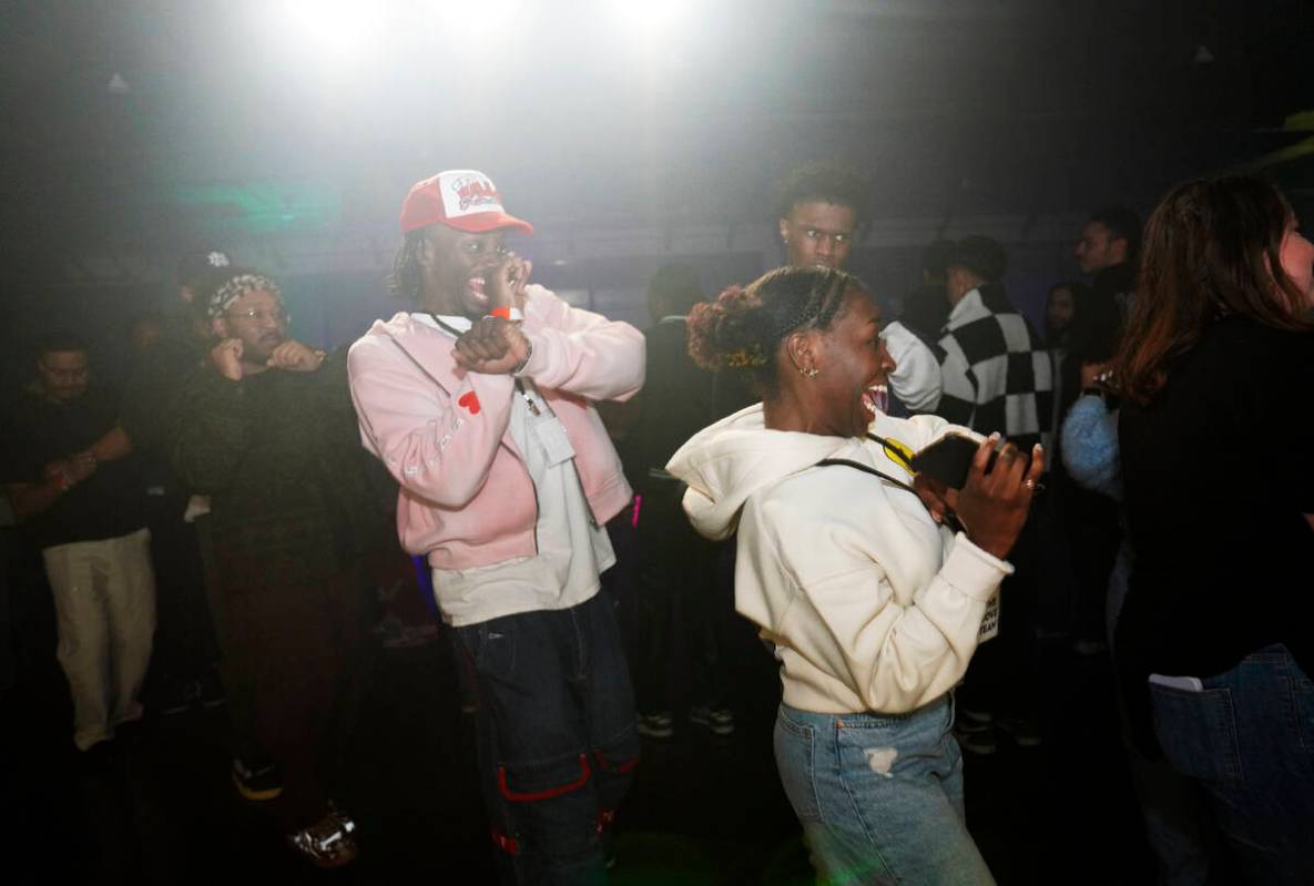 Jonathan Diggs, center, and Carlyle Coppins, right, join in a line of dancers at The Cove, a po ...