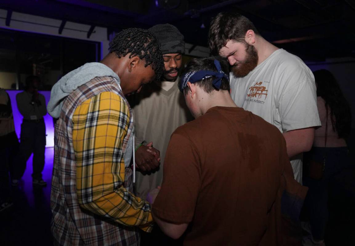 Young clubbers at The Cove, a pop-up, 18-and-up Christian nightclub, pray together after a nigh ...