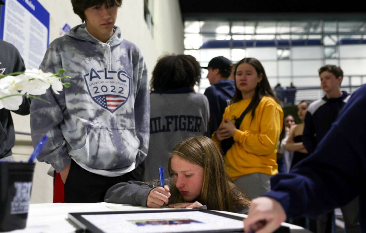 Italia Ingle writes a note to her late friend Charlie Clark during a vigil for the 19-year-old ...