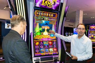 Nick Khin, right, a COO of Gaming for IGT, demonstrates how Mystery of the Lamp game is played ...
