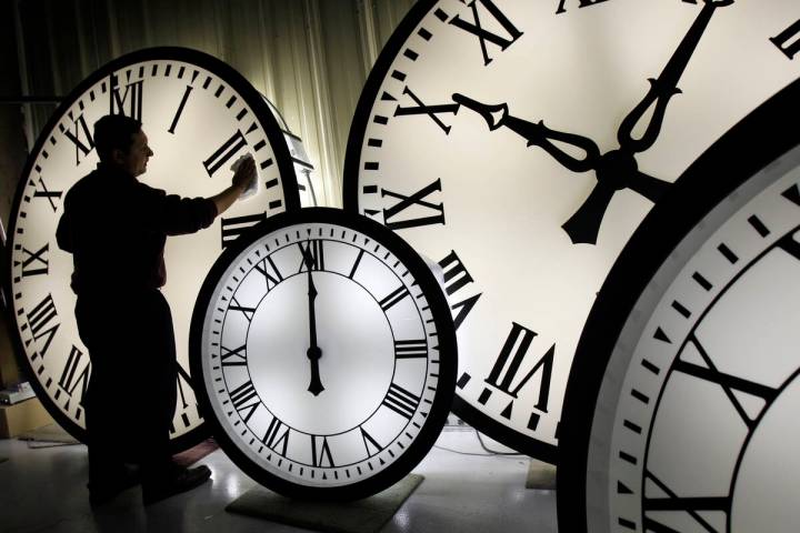 Electric Time Co. employee Walter Rodriguez cleans the face of an 84-inch Wegman clock at the p ...