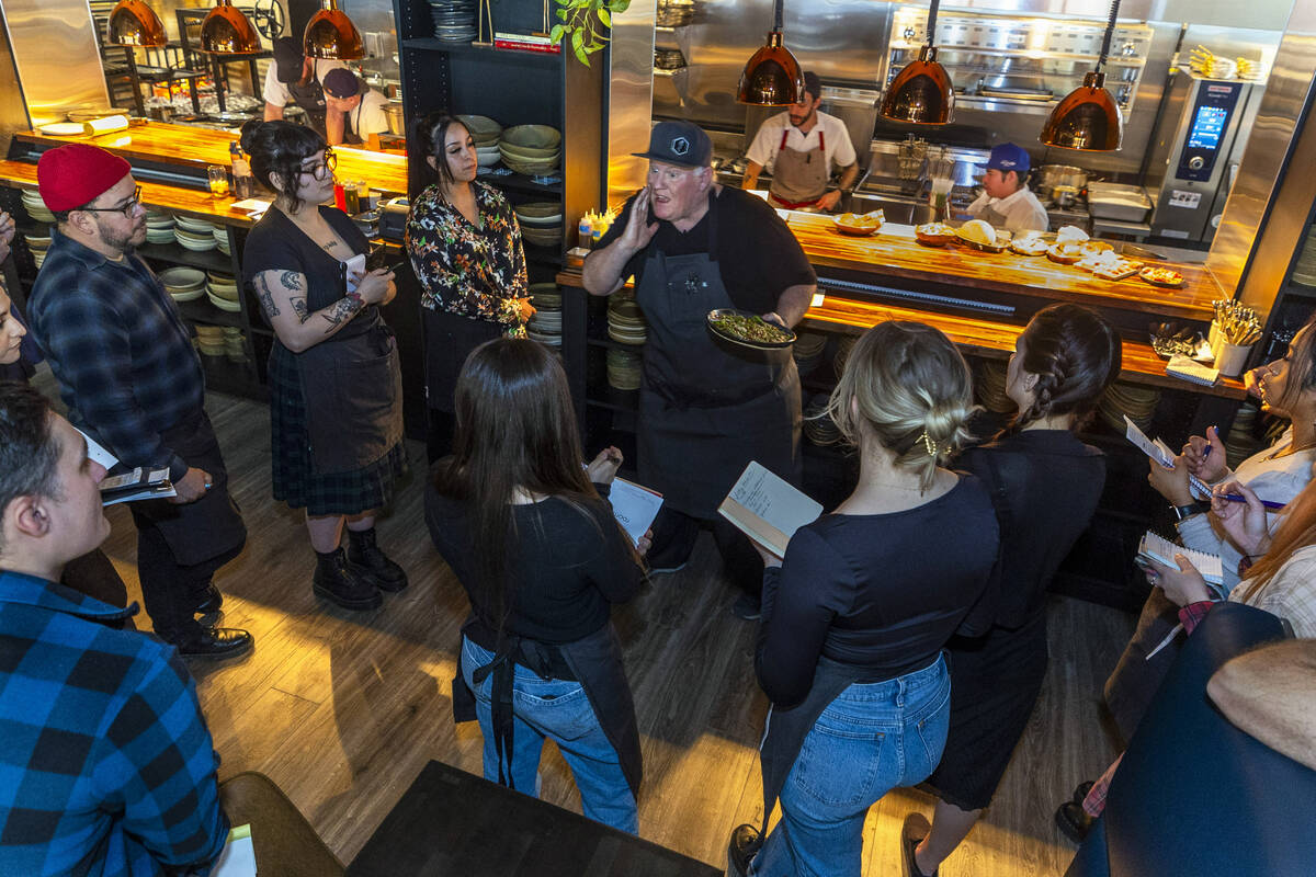 Esther's Kitchen chef/owner James Trees talks with his staff about each of their dishes as they ...