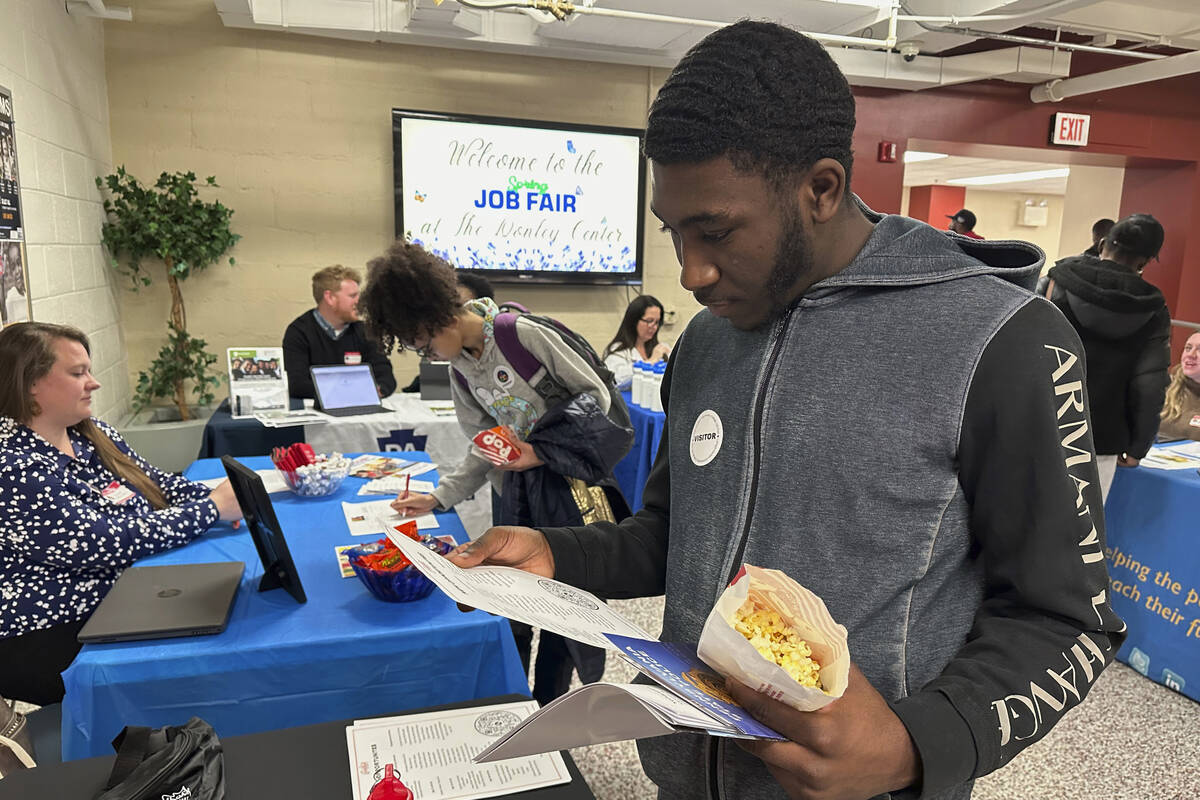 Job seeker Johannes Oveida looks over a brochure at a job fair at Lehigh Carbon Community Colle ...