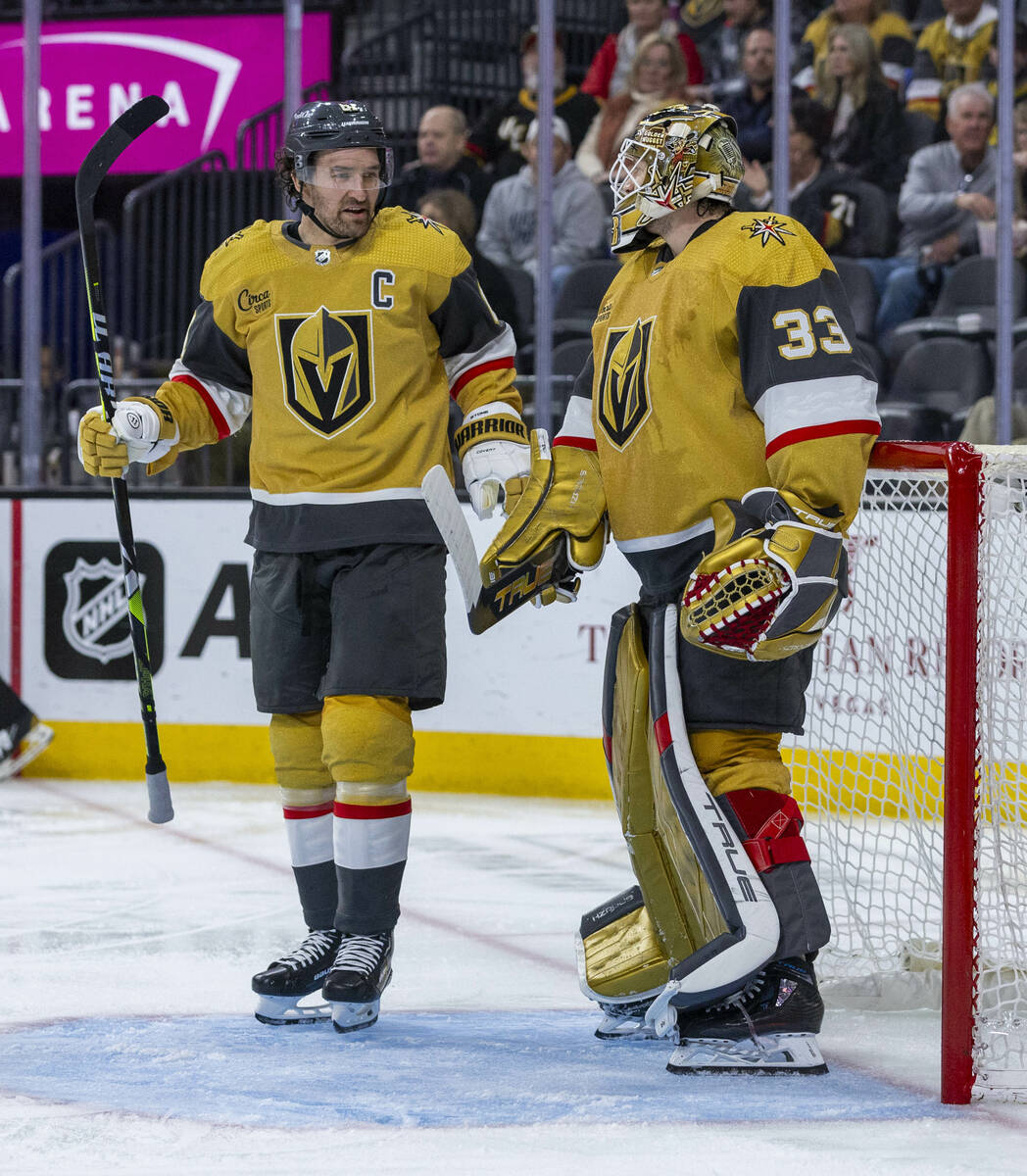 Golden Knights right wing Mark Stone (61) chats with goaltender Adin Hill (33) after an icing ...