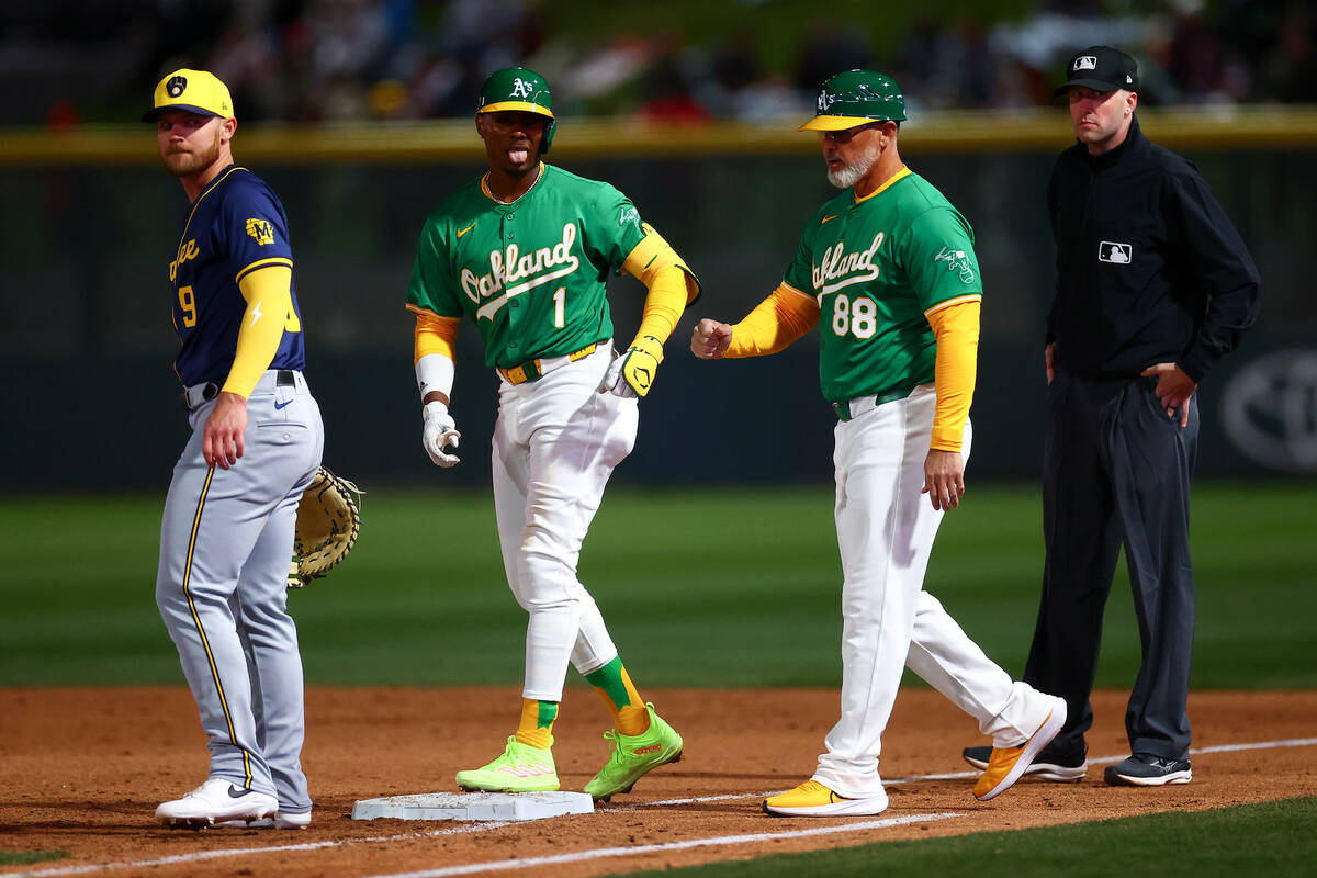 Oakland Athletics center fielder Esteury Ruiz (1) and coach Ramon Hernandez (88) react after Ru ...