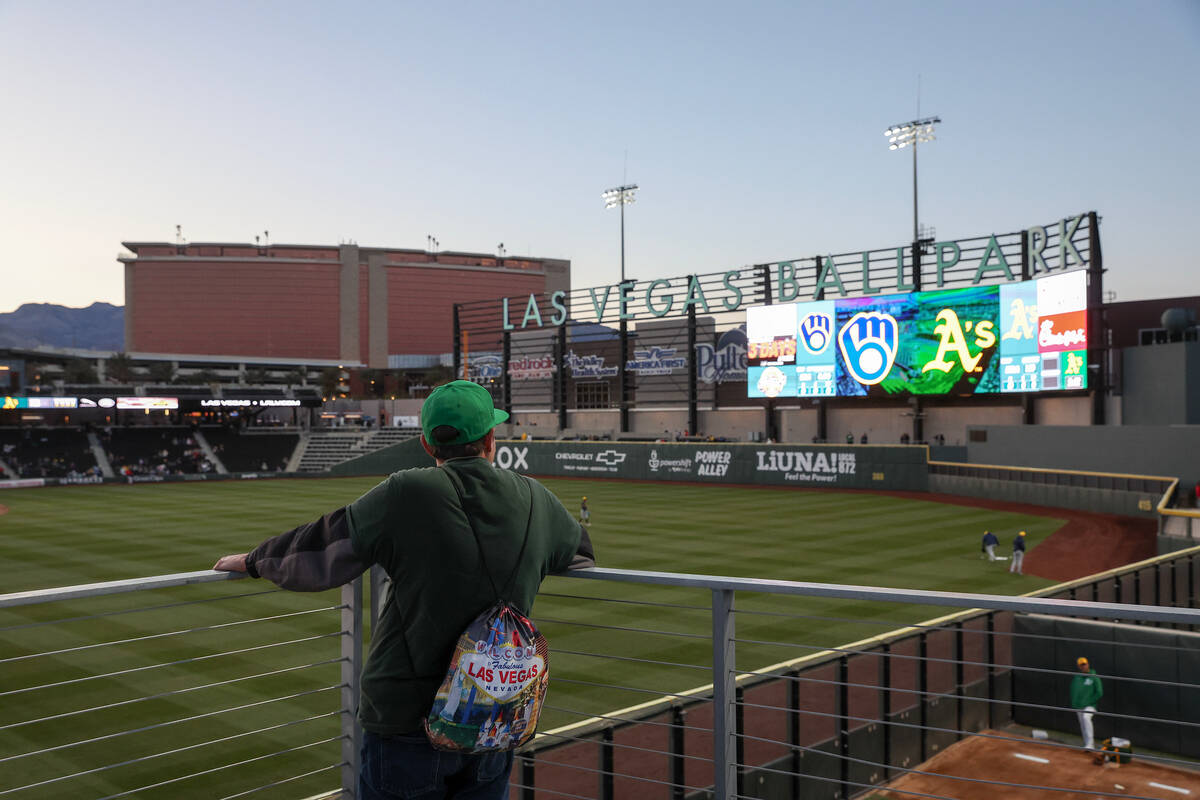 A fan looks on during warmups before a Major League Baseball spring training game between the O ...