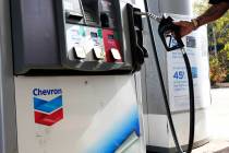 A customer replaces the pump dispenser at a Chevron gas station in Columbus, Miss., Monday, Oct ...