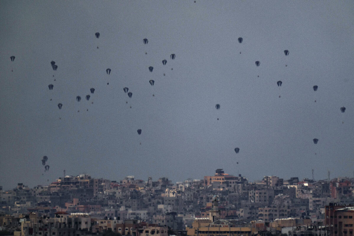 Parachutes drop supplies into the northern Gaza Strip, as seen from southern Israel, Friday, Ma ...