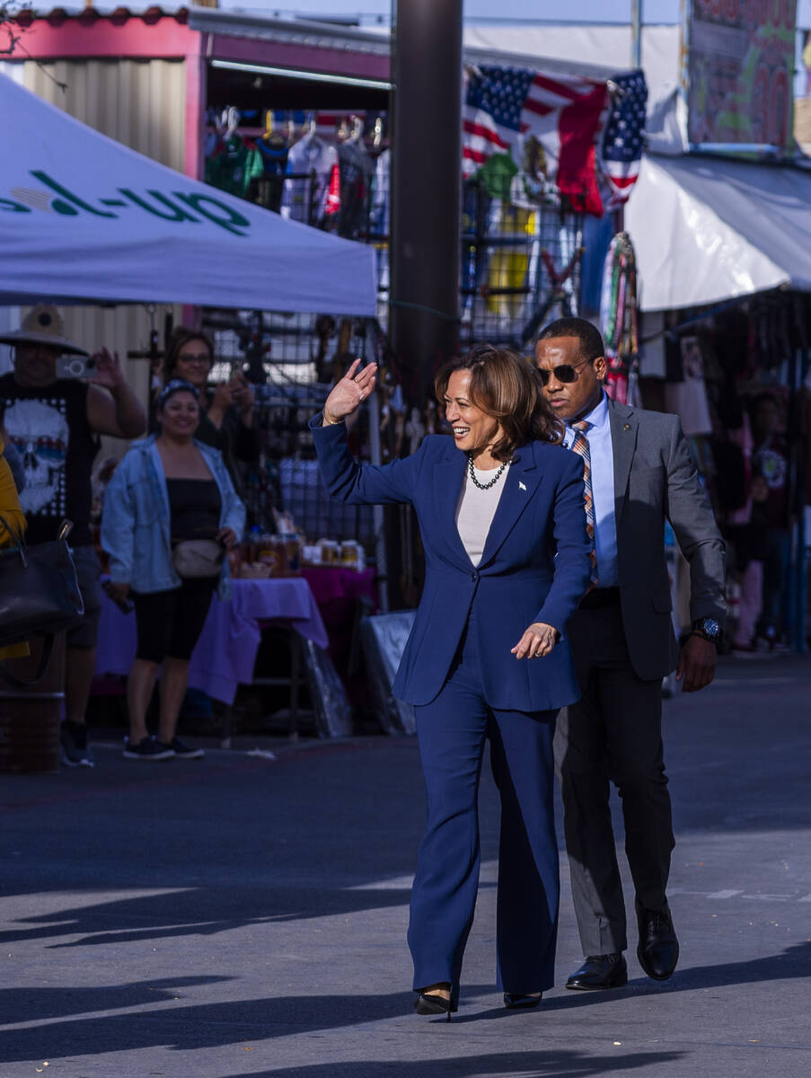 Vice President Kamala Harris waves to customers and vendors as she makes a stop to chat with pe ...