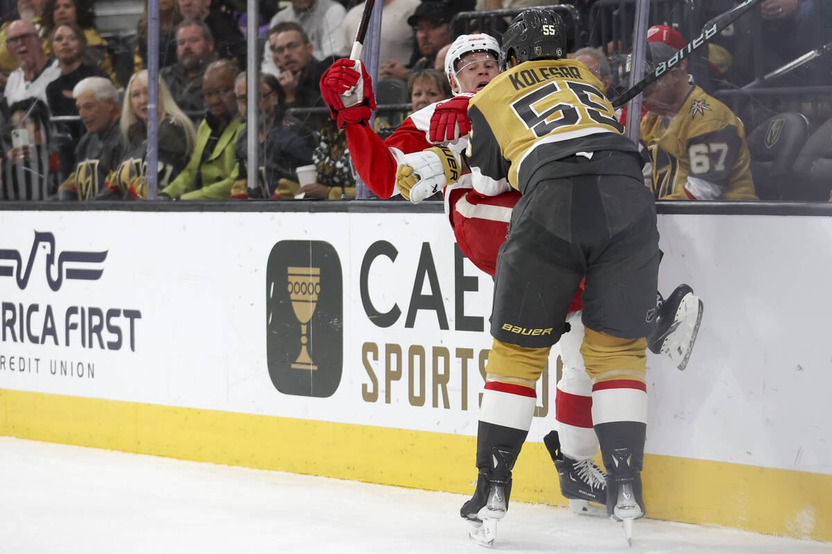 Golden Knights right wing Keegan Kolesar (55) checks Red Wings defenseman Olli Maatta (2) durin ...