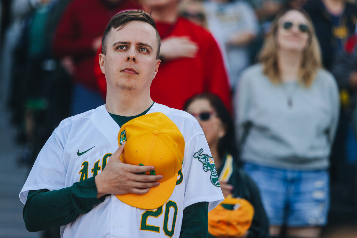 An Oakland A’s fan stands for the national anthem during a Big League Weekend game betwe ...