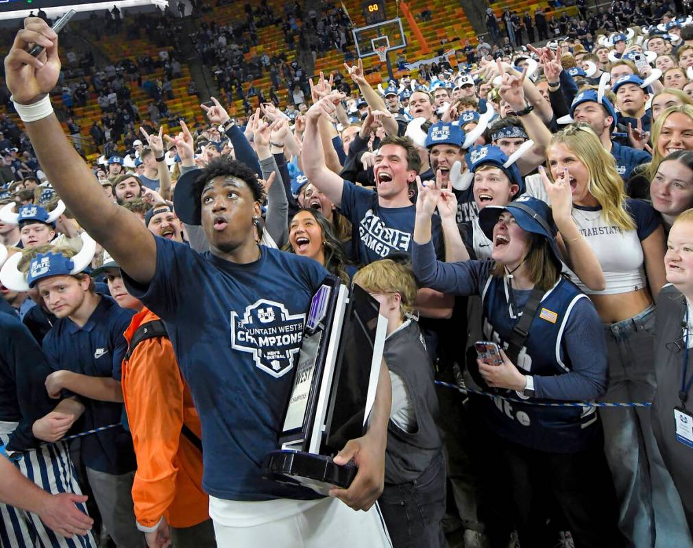Utah State forward Great Osobor celebrates with fans after the team's win over New Mexico in an ...