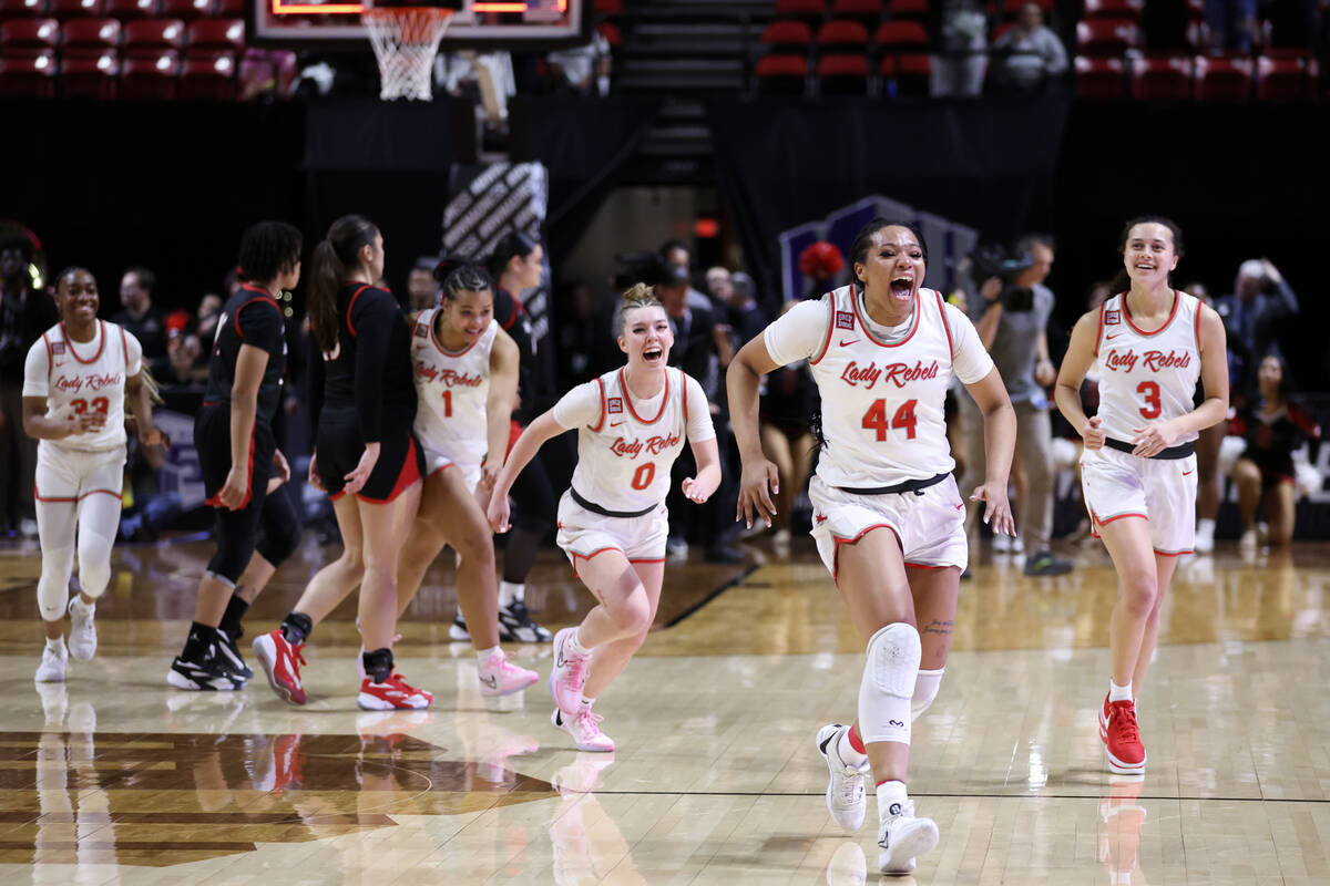 The UNLV Lady Rebels, lead by forward Alyssa Brown (44), spring to the bench as the clock runs ...