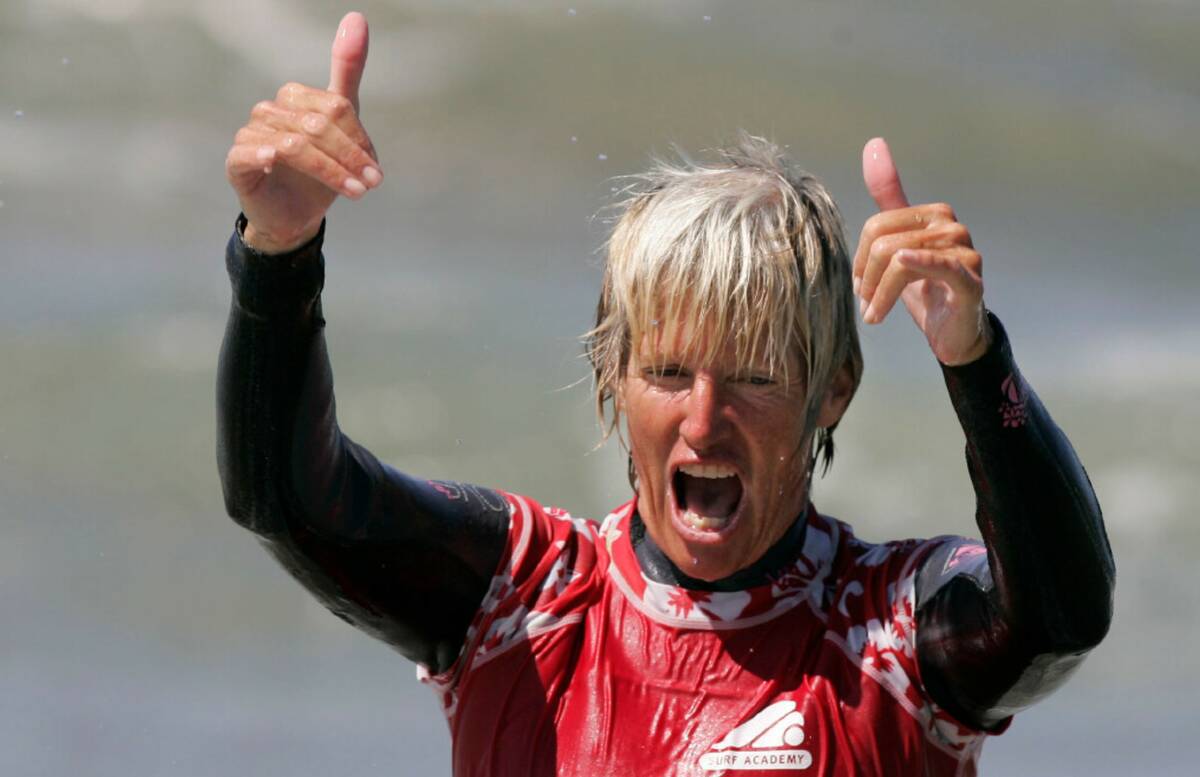 LA Surf Bus founder Mary Setterholm uses the Hawaiian "shaka" hand sign while cheering on teens ...