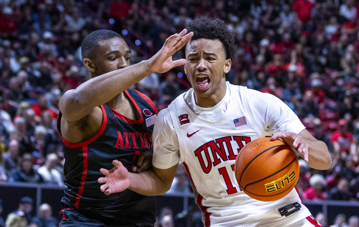 UNLV Rebels guard Dedan Thomas Jr. (11) battles to drive the lane past San Diego State Aztecs g ...