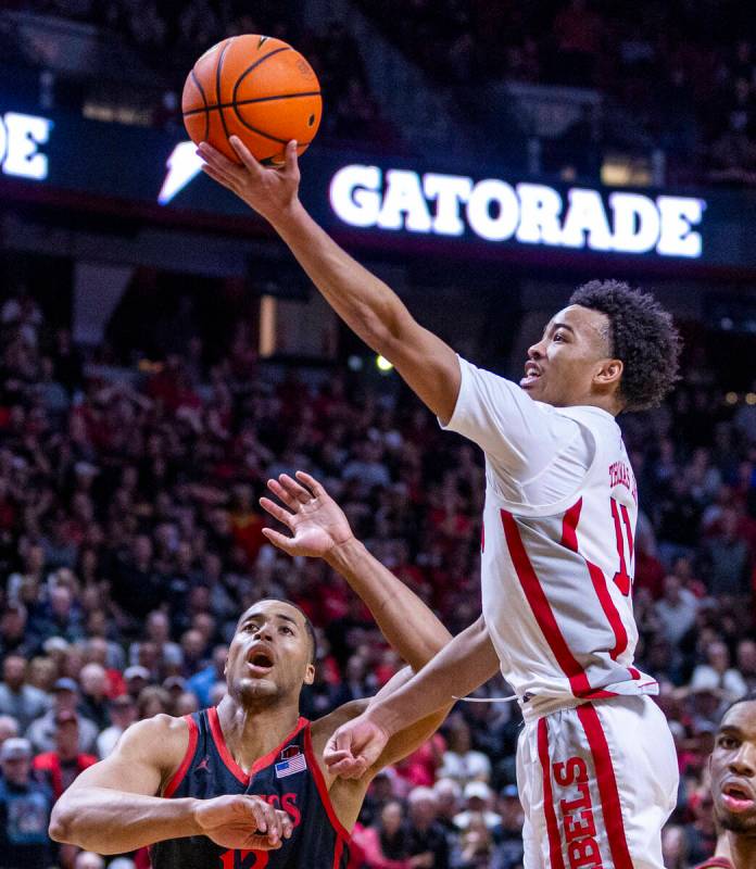 UNLV Rebels guard Dedan Thomas Jr. (11) extends to score past San Diego State Aztecs forward Ja ...