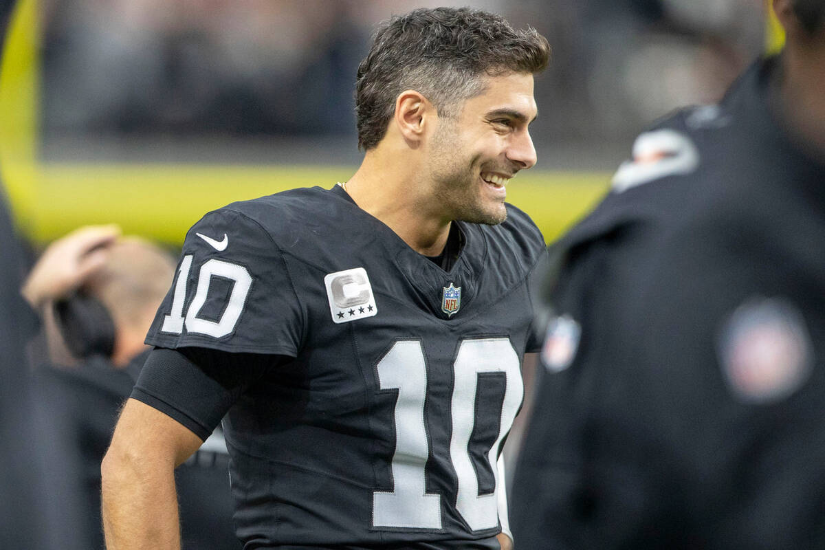 Raiders quarterback Jimmy Garoppolo (10) smiles as he watches the team play from the sideline d ...