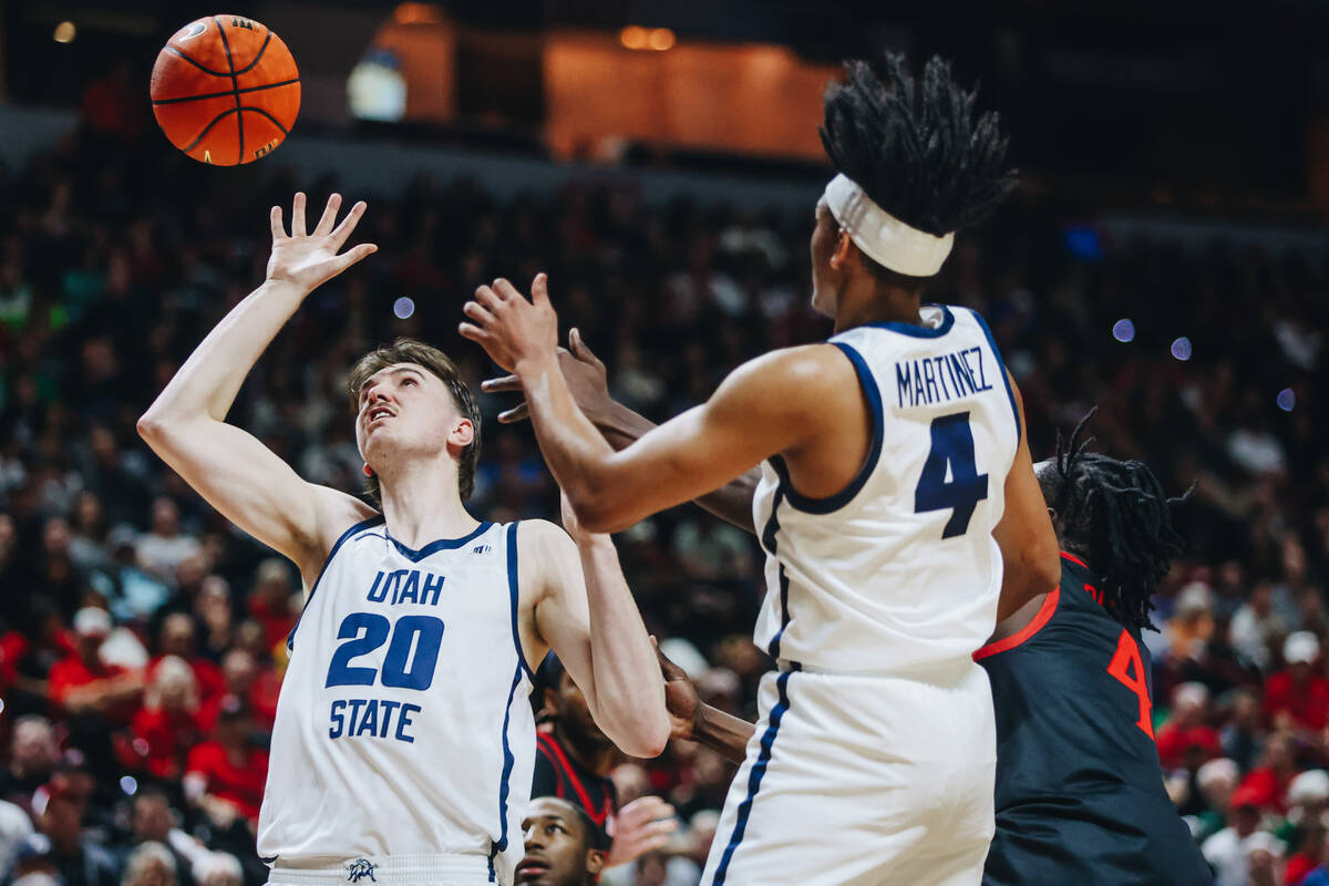 Utah State center Isaac Johnson (20) eyes the ball as it comes down after a missed shot from Sa ...