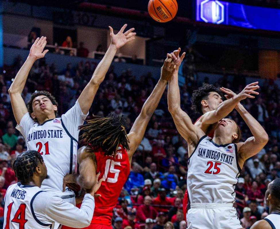 San Diego State Aztecs forward Elijah Saunders (25) is hacked on a shot by New Mexico Lobos for ...