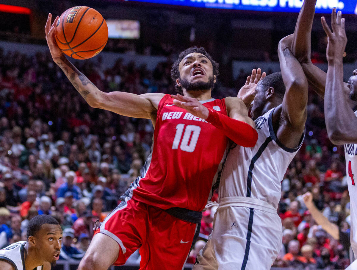 New Mexico Lobos guard Jaelen House (10) drives off of San Diego State Aztecs guard Darrion Tra ...