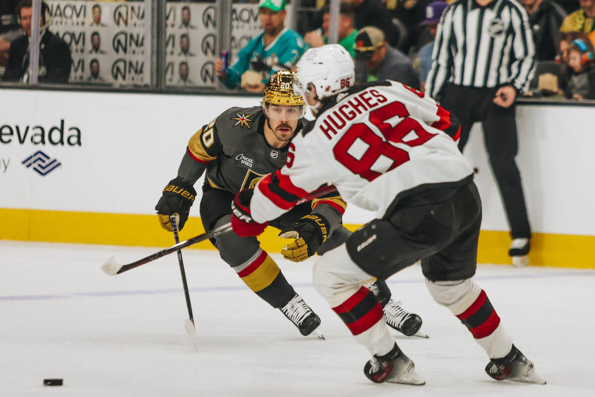 Golden Knights center Chandler Stephenson (20) andNew Jersey Devils center Jack Hughes (86) rac ...