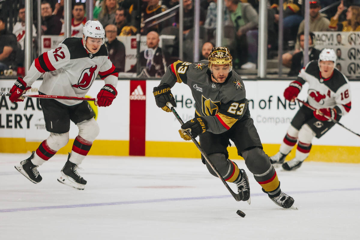 Golden Knights defenseman Alec Martinez (23) shuffles the puck across the ice during an NHL gam ...