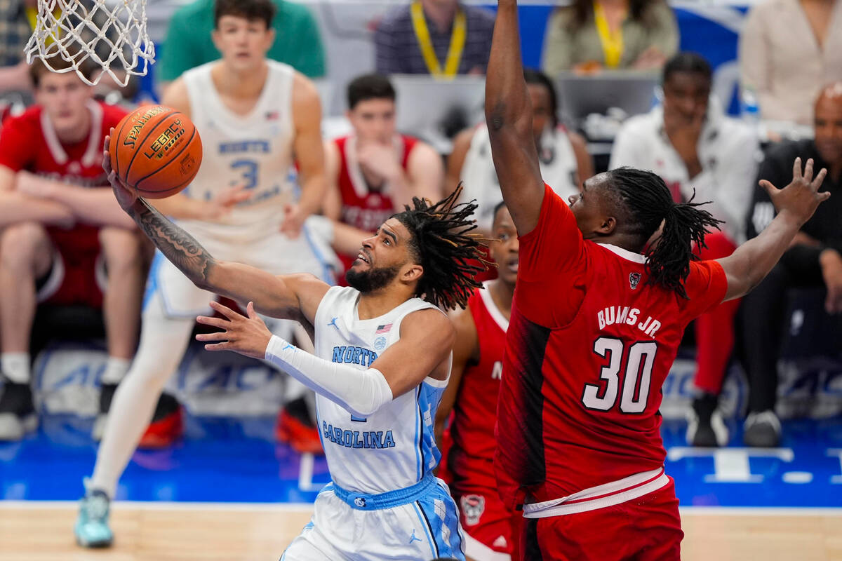 North Carolina guard RJ Davis (4) goes up for a basket against North Carolina State forward DJ ...