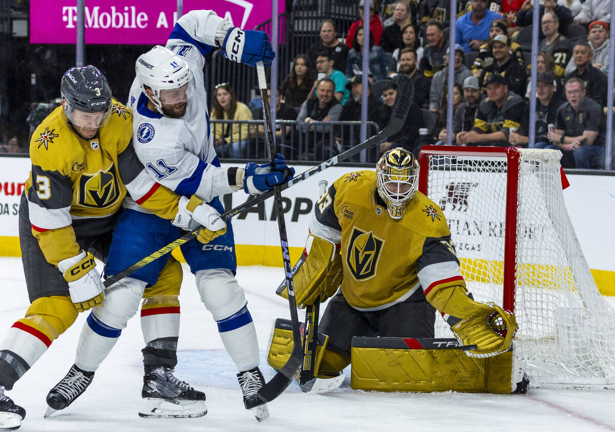 Golden Knights goaltender Adin Hill (33) readies to snag a puck as Golden Knights defenseman Br ...