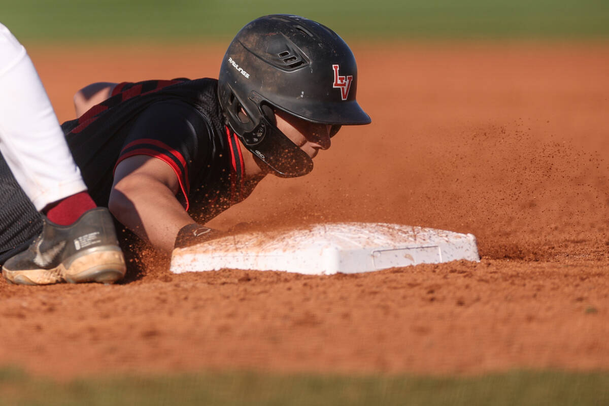 Las Vegas’ Dallas Martinez safely slides into first base after attempting to steal durin ...