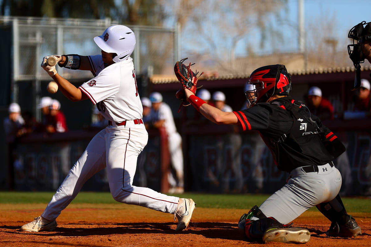 Desert Oasis’ Lucian Manzano bats against Las Vegas while their catcher Gage McCown reac ...