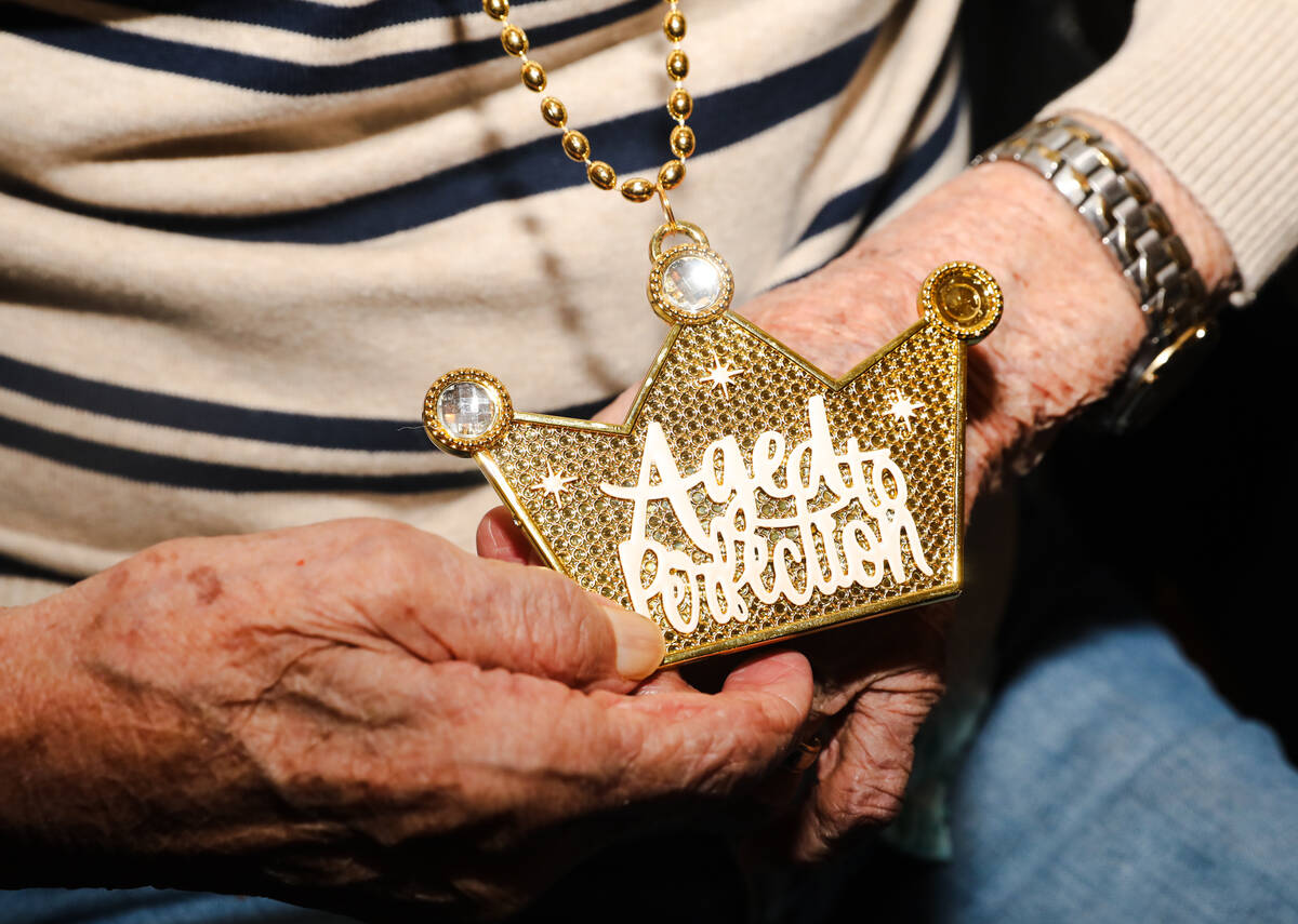 Roy Hashimura, a WW2 veteran, holds a necklace that says “aged to perfection” at his 105th ...