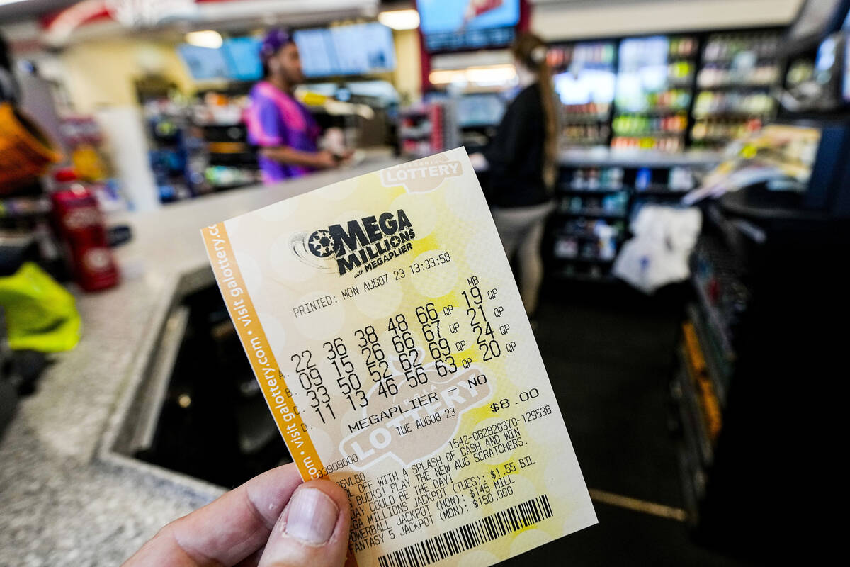 A Mega Millions ticket is seen as a person makes a purchase inside a convenience store, Aug. 7, ...