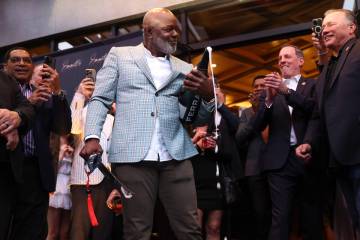 Emmitt Smith, a professional football legend, sabers a bottle of champagne during an opening ni ...