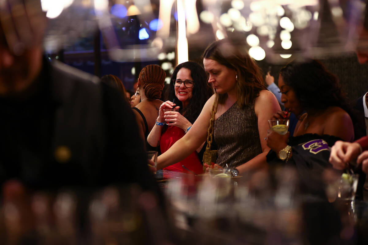 Partygoers visit the bar during an opening night party at Emmitt's Vegas in Fashion Show mall o ...