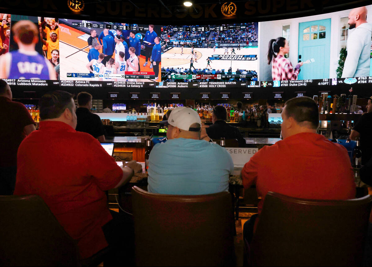 Guests watch on the big screens the first day of the NCAA basketball tournament at Westgate spo ...