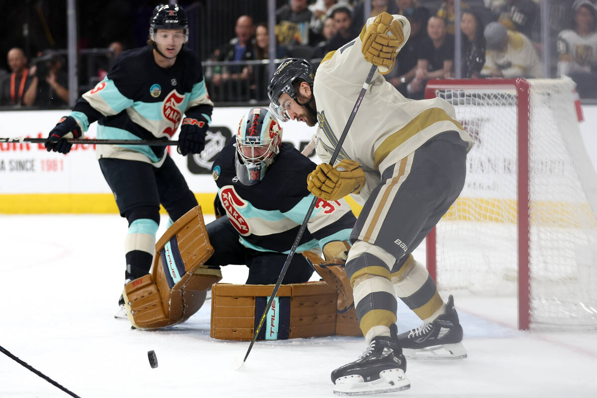 Golden Knights center Nicolas Roy (10) battles at the net with Kraken goaltender Philipp Grubau ...