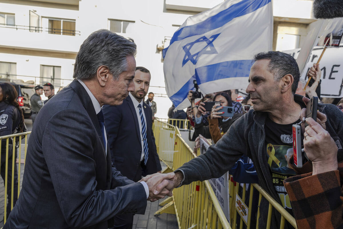 U.S. Secretary of State Antony Blinken shakes hands with a man as he meets demonstrators callin ...