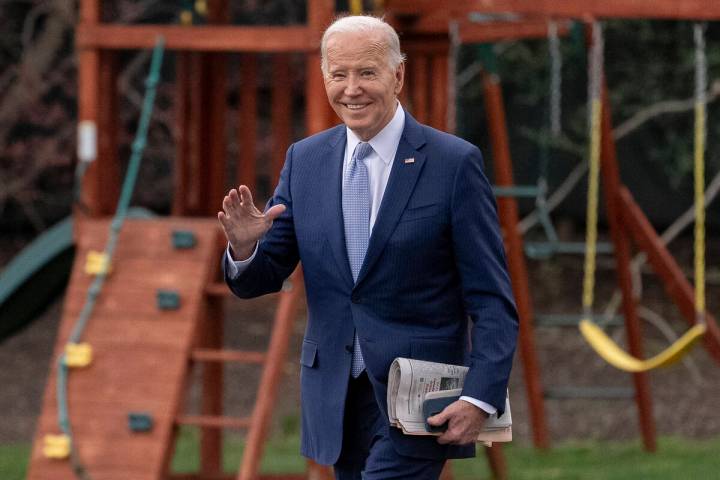 President Joe Biden waves to members of the media as he walks toward Marine One on the South La ...