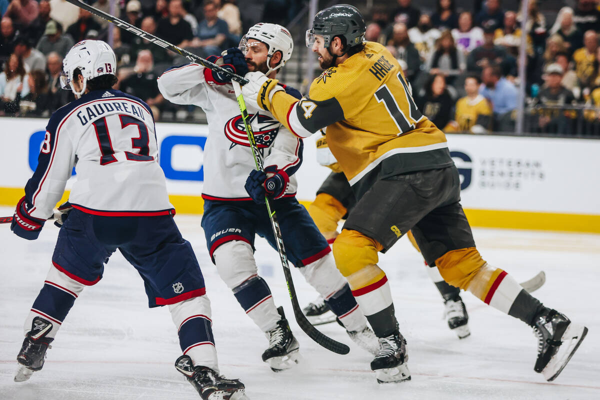 Golden Knights defenseman Nicolas Hague (14) shoves Columbus Blue Jackets left wing Dmitri Voro ...