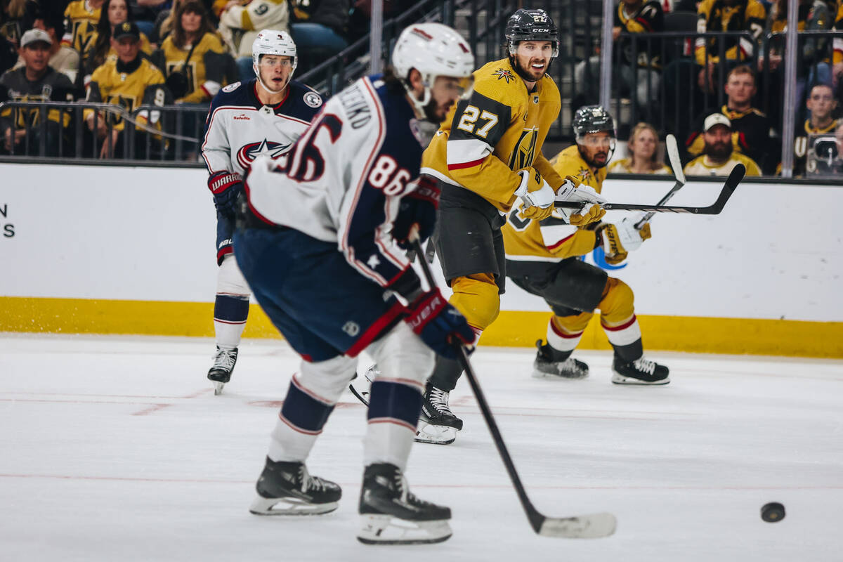 Golden Knights defenseman Shea Theodore (27) eyes the puck during an NHL hockey game between th ...