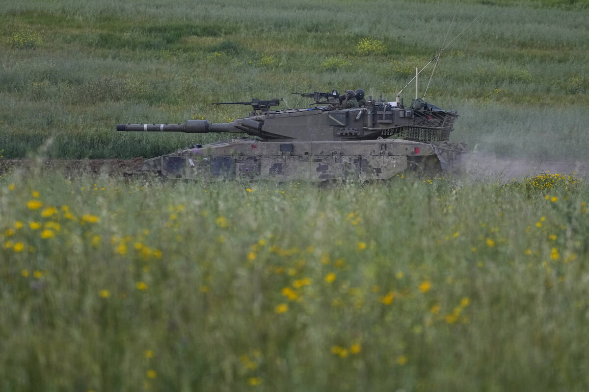 Israeli soldiers drive a tank in southern Israel, near the border with the Gaza Strip, Sunday, ...