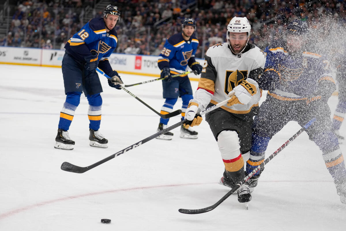 Vegas Golden Knights' Michael Amadio (22) collides with St. Louis Blues' Justin Faulk, right, a ...