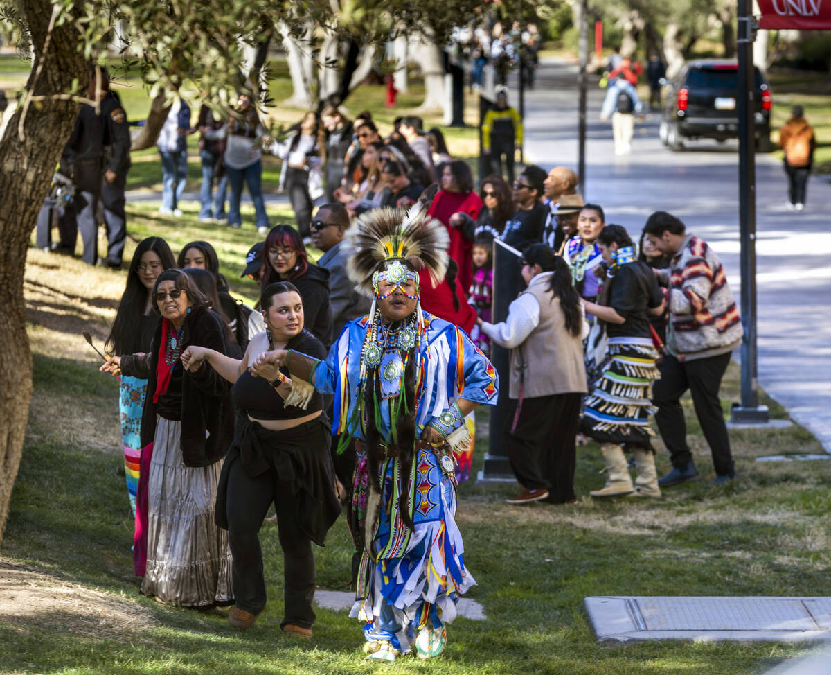 Navajo dancer Keanu Bedonie leads attendees holding hands on a round dance about the amphitheat ...