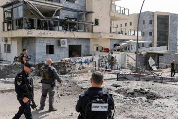 Israeli forces check a building that was hit by a Hezbollah rocket in Kiryat Shmona in northern ...