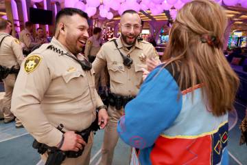Las Vegas police officers Humberto Zarate, left, and Oscar Murguia, center, are greeted Karen M ...