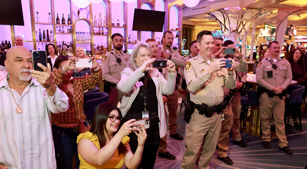 Family and co-workers take photos as Las Vegas police officers Oscar Murguia and Humberto Zarat ...