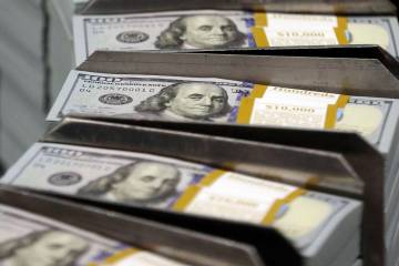 Cut stacks of $100 bills make their way down the line at the Bureau of Engraving and Printing W ...