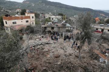 People gather on the rubble of a paramedic center that was destroyed by an Israeli airstrike ea ...