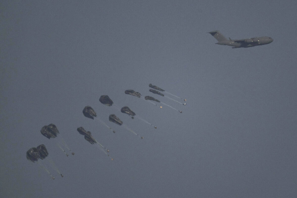 An aircraft airdrops humanitarian aid over the northern Gaza Strip as seen from southern Israel ...