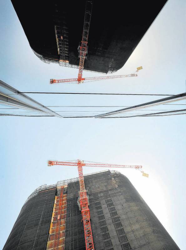 A tower crane lowers a concrete slab as the demolition continues of the unfinished Harmon Hotel ...